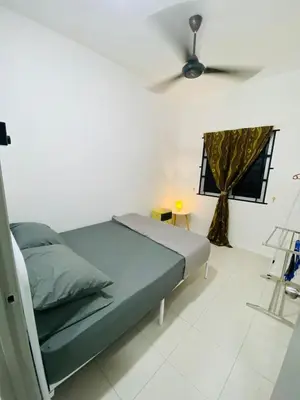 a bedroom with a bed and a ceiling fan at Baitul Mikhael Homestay in Kampong Ayer Melintas Besar
