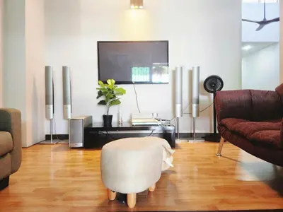 a living room with a television and a white ottoman at Ipoh Tambun pool villa 5br 18pax bbq mahjong in Tambun