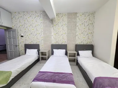 two beds in a room with two tables at Ipoh Tambun pool villa 5br 18pax bbq mahjong in Tambun
