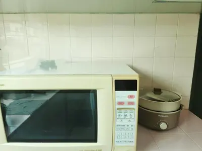 a microwave with a counter on top of it next to a toaster at Ipoh Tambun pool villa 5br 18pax bbq mahjong in Tambun