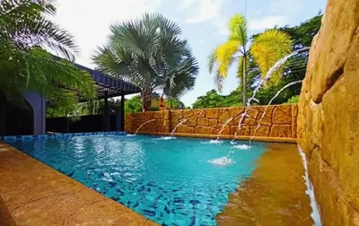 a swimming pool with blue water and palm trees at Ipoh Tambun pool villa 5br 18pax bbq mahjong in Tambun