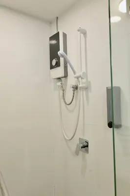a shower in a bathroom with a hose attached to a wall at Maritime Suite Full Seaview Georgetown in George Town