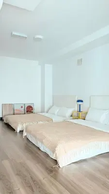 two beds in a white room with wooden floors at Maritime Suite Full Seaview Georgetown in George Town