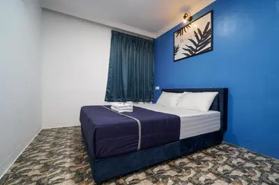a blue bedroom with a bed with a blue wall at BOSS Hotel in Ipoh