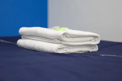 a pile of towels sitting on top of a bed at BOSS Hotel in Ipoh