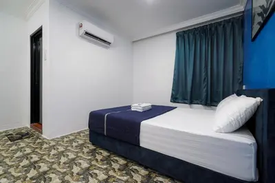 a bedroom with a bed with a blue window at BOSS Hotel in Ipoh