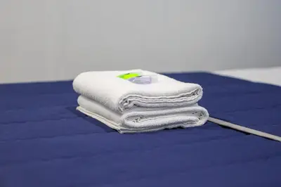 a pile of towels sitting on top of a bed at BOSS Hotel in Ipoh