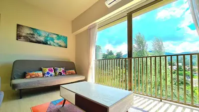 a living room with a couch and a large window at By The Sea - Beachfront Bliss at Batu Ferringhi in Batu Ferringhi