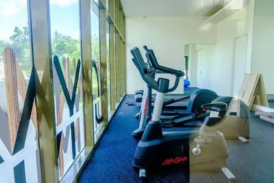 a gym with treadmills and ellipticals in a room at By The Sea - Beachfront Bliss at Batu Ferringhi in Batu Ferringhi