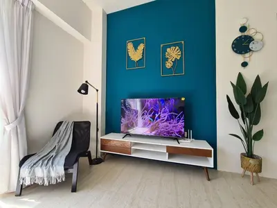 a living room with a fish tank on a cabinet at By The Sea - Beachfront Bliss at Batu Ferringhi in Batu Ferringhi