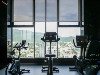 a gym with exercise bikes in front of a window at 22 Macalisterz by MyKey in George Town