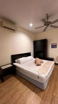 a bedroom with a white bed with a ceiling fan at Tower Regency Hotel & Apartments in Ipoh