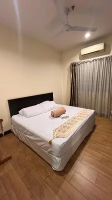 a bedroom with a white bed with a window at Tower Regency Hotel & Apartments in Ipoh
