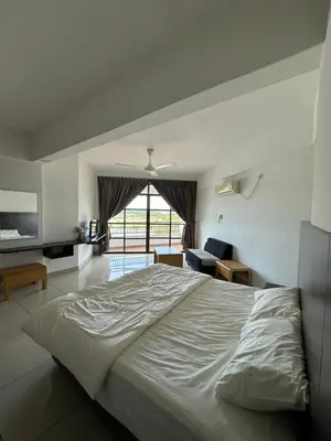 a bedroom with a large bed and a living room at Homestay in Marina Heights with beach view in Lumut