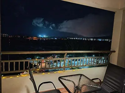 a balcony with a view of a city at night at Homestay in Marina Heights with beach view in Lumut