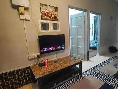a living room with a television and a table at RZ HOMESTAY With WiFi in Sungai Siput