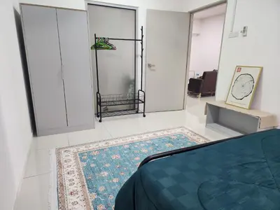 a bedroom with a bed and a clock on the wall at Family Haven at Paragon in Gua Sai