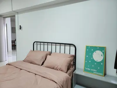 a bed in a bedroom with a white wall at Family Haven at Paragon in Gua Sai