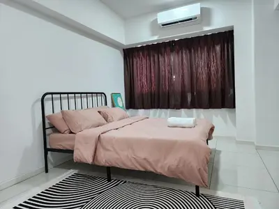 a bedroom with a bed with pink sheets at Family Haven at Paragon in Gua Sai