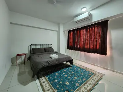 a bedroom with a bed and a rug and a window at Family Haven at Paragon in Gua Sai