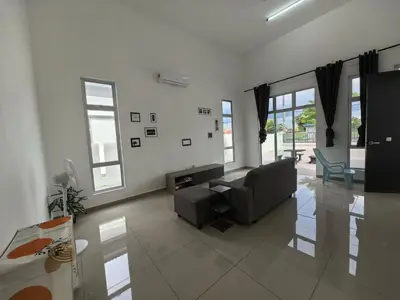 a living room with a couch and some windows at Padang Serai Wangi Homestay 55 in Gua Sai