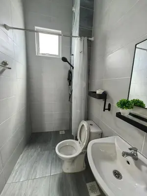 a white bathroom with a toilet and a sink at Padang Serai Wangi Homestay 55 in Gua Sai