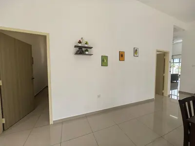 a room with a white wall with pictures on it at Padang Serai Wangi Homestay 55 in Gua Sai