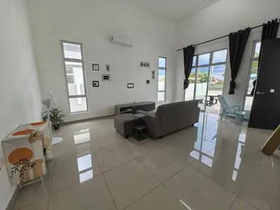 a living room with a couch and a chair at Padang Serai Wangi Homestay 55 in Gua Sai