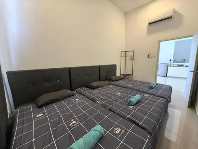 a bedroom with a large bed with blue pillows at Padang Serai Wangi Homestay 63 in Padang Serai