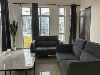 a living room with a couch and a glass table at Padang Serai Wangi Homestay 63 in Padang Serai