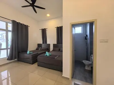 a living room with a couch and a ceiling fan at Padang Serai Wangi Homestay 63 in Padang Serai