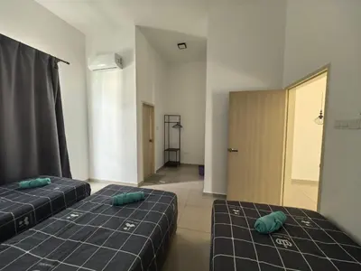 two beds in a room with a hallway at Padang Serai Wangi Homestay 63 in Padang Serai