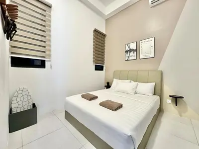a bedroom with a large bed with white sheets at Urban Suites #Tiny walnut 2BR1bath suite #Infinity Pool #4pax #2 Queens #Quality well maintained #Private host in Jelutong