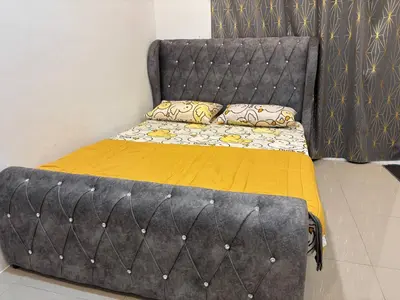 a bed with yellow sheets and pillows on it at Healing Homestay in Kampong Changkat Sedonan