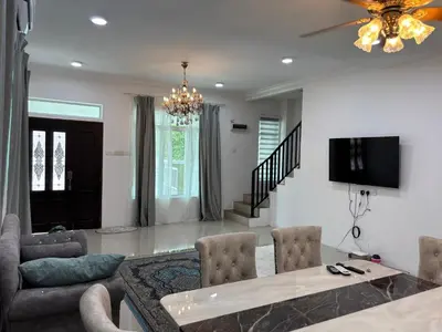 a living room with a dining table and a chandelier at Healing Homestay in Kampong Changkat Sedonan