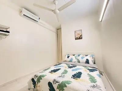 a white bedroom with a bed with leaves on it at Cozy AiZHome in Balik Pulau