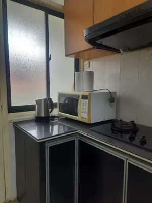 a kitchen with a microwave and a counter top at Cozy AiZHome in Balik Pulau
