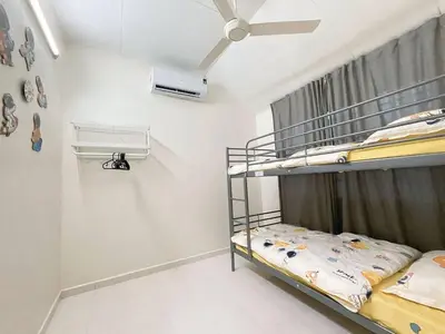 a bedroom with two bunk beds and a ceiling fan at Cozy AiZHome in Balik Pulau