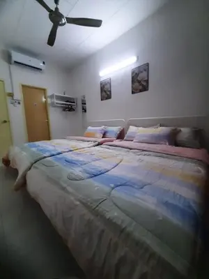 a large bed in a bedroom with a ceiling fan at Cozy AiZHome in Balik Pulau