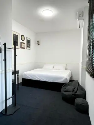 a bedroom with a bed and a chair in it at Bali Nordic American Guest House Style By Nest at Beach St George Town Penang in George Town