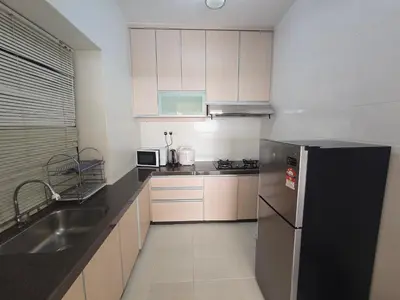 a kitchen with a black refrigerator and a sink at Sunshine Seaview Apartment in Batu Ferringhi