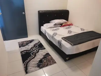 a bedroom with a bed with a black headboard and a rug at 1132 D' KHASIEH Homestay in Kampong Sungai Wangi Dalam