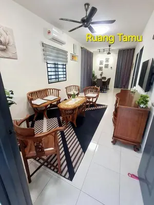 a living room with a table and wooden chairs at 1132 D' KHASIEH Homestay in Kampong Sungai Wangi Dalam