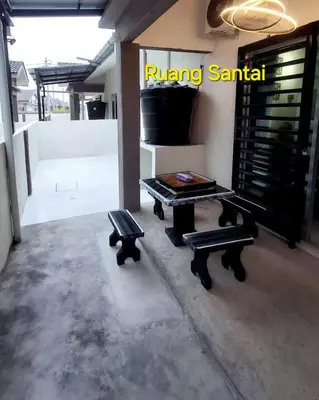 a room with a table and benches in a building at 1132 D' KHASIEH Homestay in Kampong Sungai Wangi Dalam