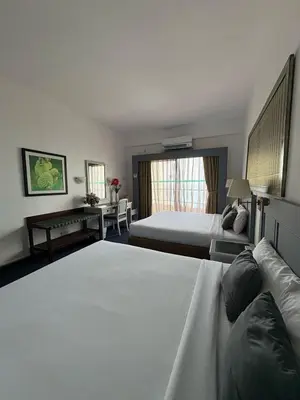 a hotel room with two beds and a desk at Sky beach resort in Tanjung Bungah