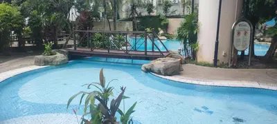 a swimming pool with a bridge in a resort at Sky beach resort in Tanjung Bungah
