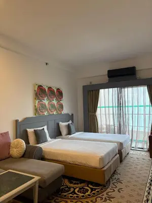 a hotel room with two beds and a couch at Sky beach resort in Tanjung Bungah