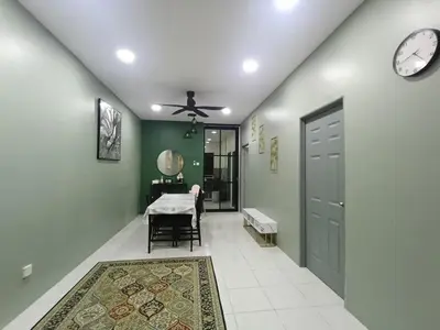 a hallway with a table and a clock on the wall at Teratak Arissa Homestay in Sitiawan