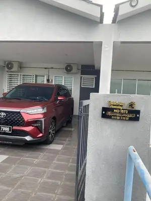 a red suv parked in a parking lot at Teratak Arissa Homestay in Sitiawan