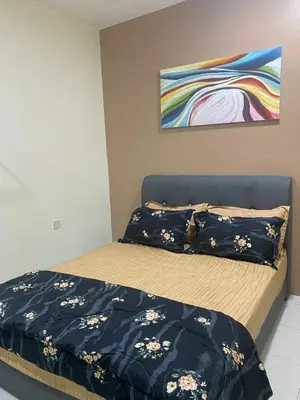 a bedroom with a bed with black sheets and a painting at Teratak Arissa Homestay in Sitiawan
